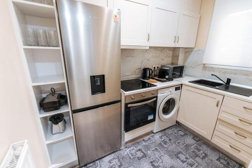 eine Küche mit einem Kühlschrank, einer Waschmaschine und einem Trockner in der Unterkunft Peaceful moments in Athen