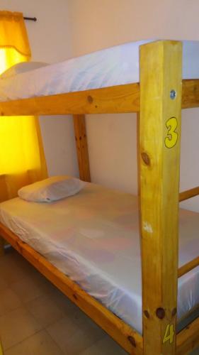 two bunk beds in a room with white sheets at Taganga Paradise Hostal Diving in Taganga