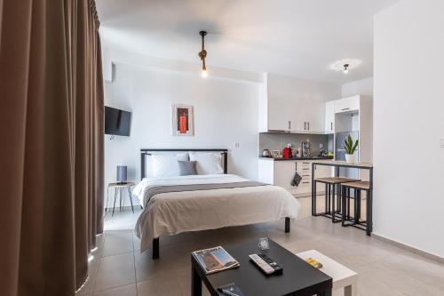 een slaapkamer met een bed en een kleine keuken bij Pagani Green - Luxury Studio A2 in Faraí