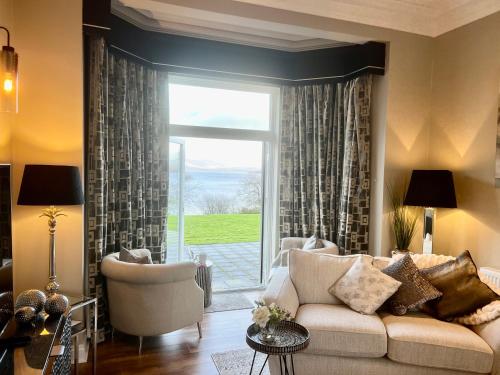 sala de estar con sofá y ventana grande en Loch View at Lomond Castle, en Balloch