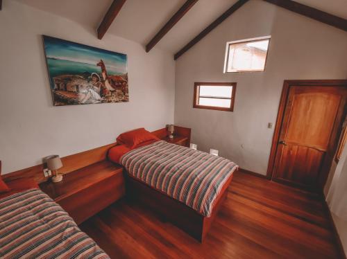 - une chambre avec 2 lits et un tableau mural dans l'établissement Ecolodge Santo Campo, à Isla de Sol
