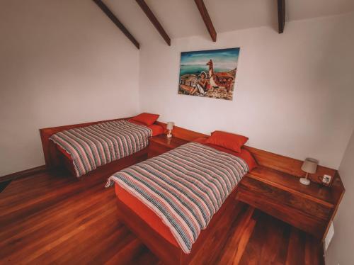 two beds in a room with wooden floors at Ecolodge Santo Campo in Isla de Sol