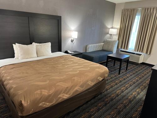 a hotel room with a bed and a chair at Quality Inn in Ashland