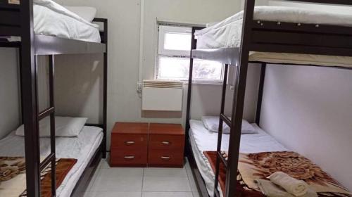 Goderdzi的住宿－hostel mari，宿舍间设有两张双层床和一扇窗户。