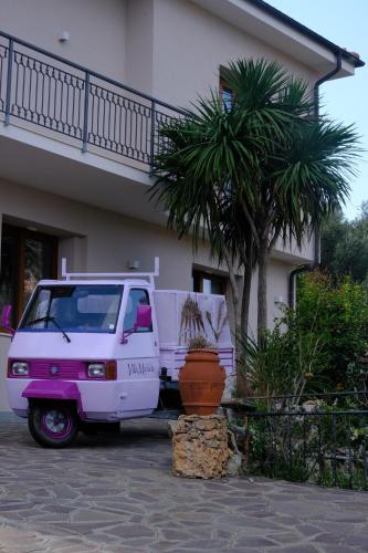 a pink and white van parked in front of a house at Villa Mafalda in Pietra Ligure