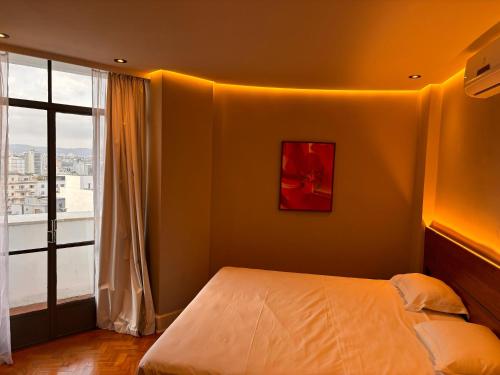 a bedroom with a bed and a large window at San Raphael Hotel in Sao Paulo