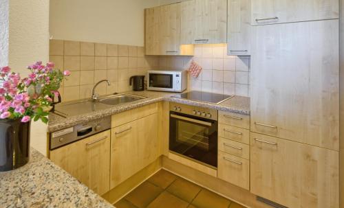 a kitchen with a sink and a microwave at Flair Hotel Schwanen in Bad Bellingen