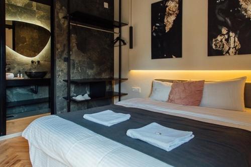 1 dormitorio con 1 cama con 2 toallas en Gray Apartments, en Strumica