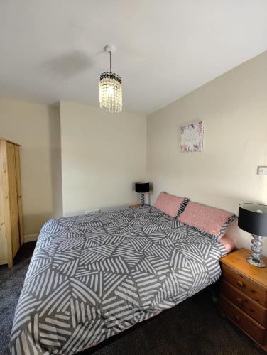 um quarto com uma cama e uma cómoda com um candeeiro em Anstuns LODGE em Liverpool