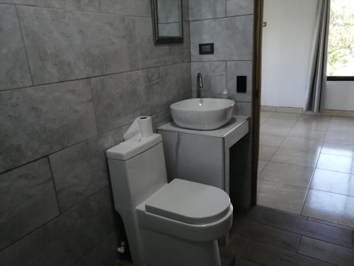 a bathroom with a white toilet and a sink at Mirada al Cerro, Apartamento completo in Grecia