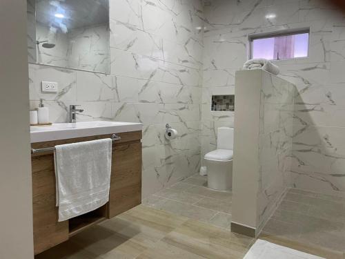 uma casa de banho branca com um lavatório e um WC em Alka's Paradise Guest House and Lodging em San Andrés