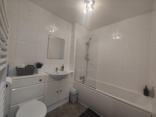 biała łazienka z umywalką, toaletą i wanną w obiekcie Modern 2-Bed Gem! Prime M22 Location Near Airport, Hospital & Sleeps 7 w mieście Wythenshawe