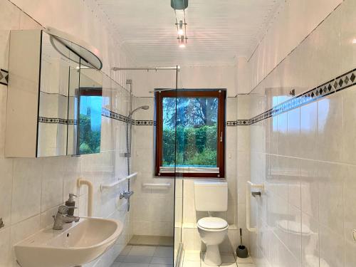 a white bathroom with a sink and a toilet at My Loft by Essen 2 Apartments in Rosengarten