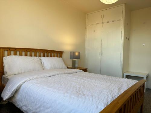 Amazing Room in Glasgow City في غلاسكو: غرفة نوم بسرير ابيض كبير مع خزانة