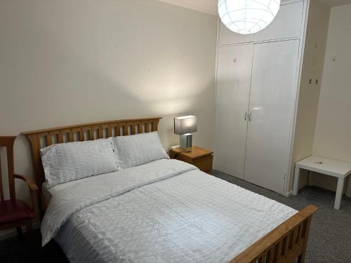 Amazing Room in Glasgow City في غلاسكو: غرفة نوم بسرير ومصباح على طاولة
