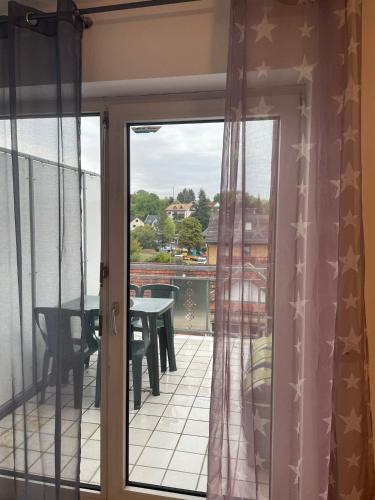 a sliding glass door to a balcony with a table at APARTMENT / WOHNUNG IN GOLDBACH in Goldbach