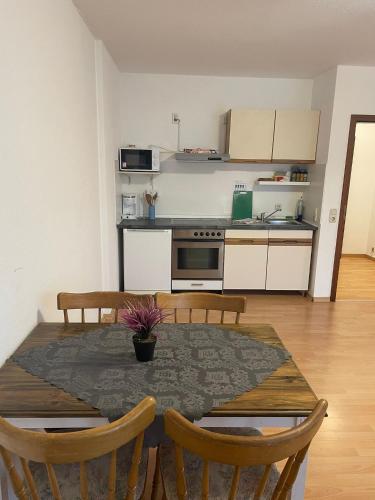 APARTMENT / WOHNUNG IN GOLDBACH في Goldbach: مطبخ وغرفة طعام مع طاولة وكراسي