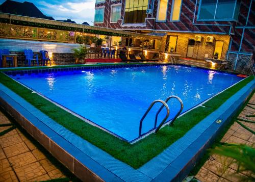 a large blue swimming pool with grass around it at Portland Resort Hotel in Port Harcourt