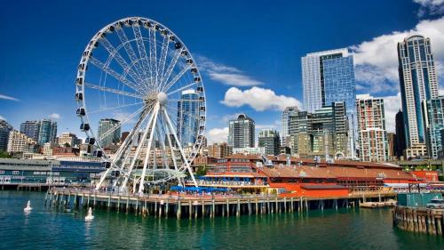 a ferris wheel sitting in the water near a city at New modern Nordic style home, View, Rooftop deck in Seattle