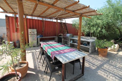 una mesa de picnic bajo una pérgola en un patio trasero en Pericu Bed and Garden, en La Ventana