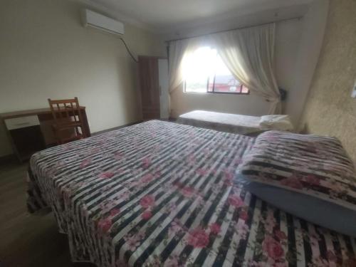 1 dormitorio con 1 cama con edredón en Apartamento Margarida, en Foz do Iguaçu