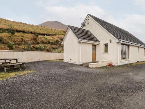a white building with a picnic table next to it at Tigh na Creag in Sconser