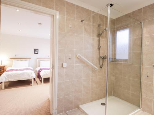 a bathroom with a walk in shower next to a bedroom at Tigh na Creag in Sconser