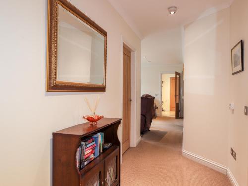 a hallway with a mirror and a table with books at Tigh na Creag in Sconser