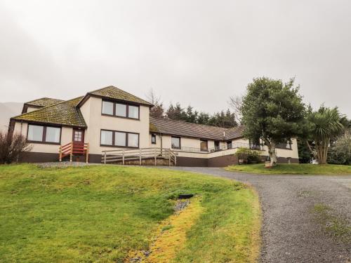 a house on a grassy hill with a driveway at MacKenzies Peak in Sconser