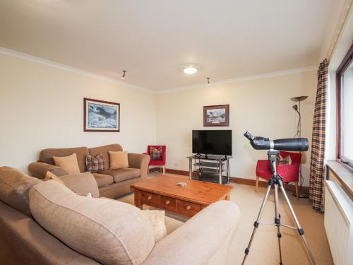 a living room with a couch and a camera at MacKenzies Peak in Sconser