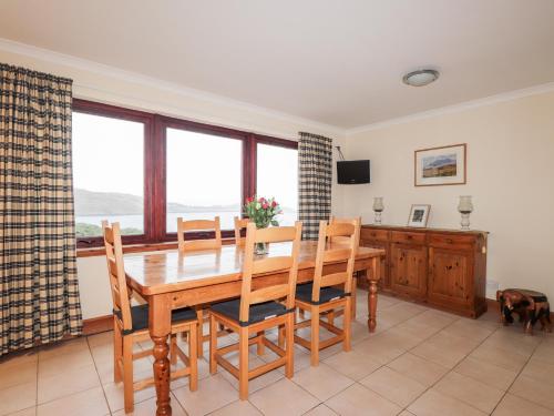 a dining room with a wooden table and chairs at MacKenzies Peak in Sconser