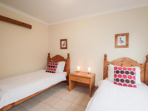 a room with two beds and a nightstand between them at MacKenzies Peak in Sconser