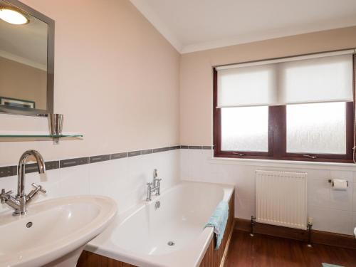 a white bathroom with a sink and a window at MacKenzies Peak in Sconser