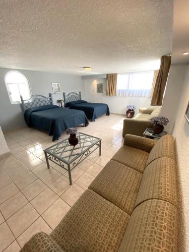 a living room with two beds and a couch at Hotel Qualitel Plus in Morelia