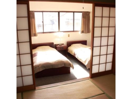 - un miroir dans une chambre avec 2 lits dans l'établissement Travel Inn Yoshitomi - Vacation STAY 37637v, à Taketa