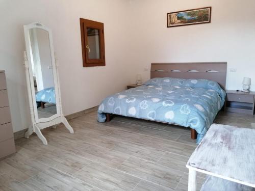 a bedroom with a bed and a mirror at Appartamento Scirocco in Marina di Campo