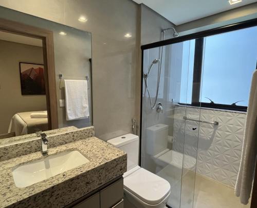 a bathroom with a toilet and a sink and a shower at Life Residence in Belo Horizonte