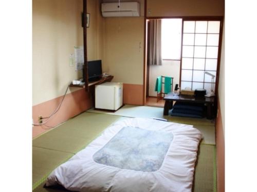 une chambre avec un lit au milieu d'une pièce dans l'établissement Travel Inn Yoshitomi - Vacation STAY 37633v, à Taketa