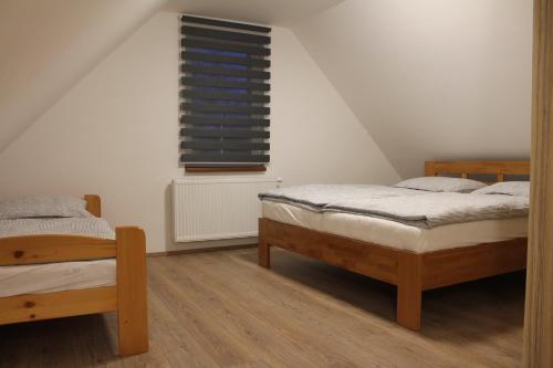 two twin beds in a room with a window at Apartmány 264 in Albrechtice v Jizerských horách