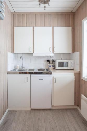 a kitchen with white cabinets and a sink at Strandgården Fjällnäs in Tänndalen