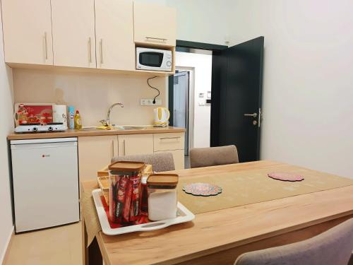 a kitchen with a wooden table and a table and chairs at Apartman City Peace Sarajevo, 72 m2, free parking in Sarajevo