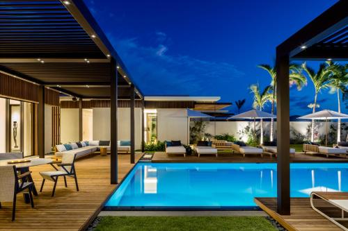 an outdoor patio with a swimming pool and a house at Silversands Resort Grenada at Grand Anse in Grand Anse