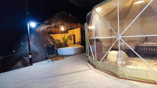 a room with a tub in a tent at night at Lunda Orchid Resort in Suan Phung