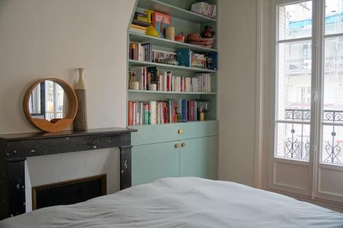 - une chambre avec un lit et une cheminée avec un miroir dans l'établissement Family flat, 15' away from Paris city center, à Asnières-sur-Seine