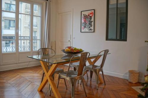 - une table à manger avec des chaises et une corbeille de fruits dans l'établissement Family flat, 15' away from Paris city center, à Asnières-sur-Seine