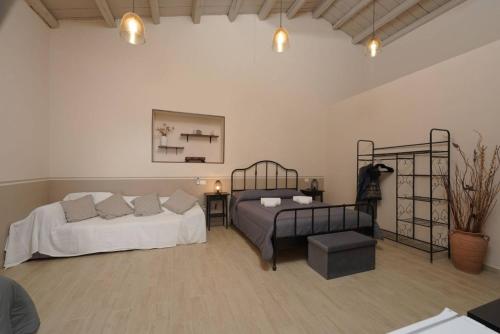 a bedroom with two beds and a couch in it at SyracuseApartments Antica Dimora in Siracusa