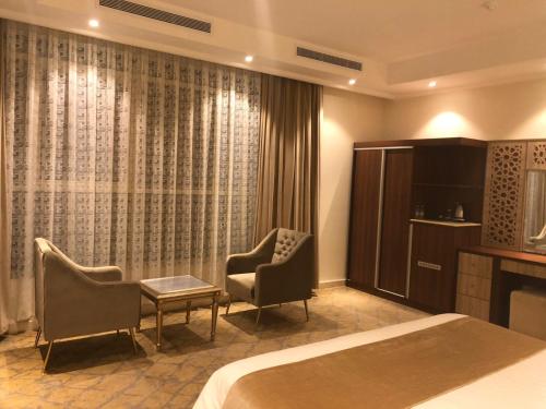 a hotel room with a bed and two chairs at درة العروس للوحدات السكنية المفروشة in Jeddah