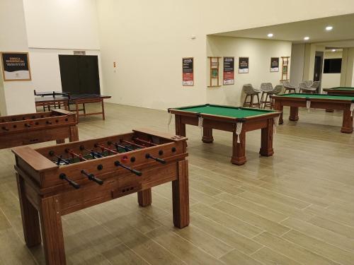 a room with three ping pong tables in it at Vizinho à igrejinha - Apartamento completo no ECO RESORT Praia dos Carneiros in Praia dos Carneiros