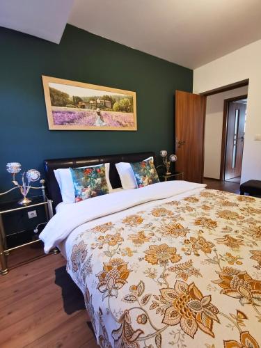 - une chambre avec un grand lit et un mur vert dans l'établissement Sinaia Central Park, à Sinaia