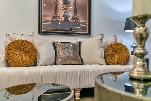 a living room with a couch with pillows on it at Royale Palace - Rooftop Pool &Spa in Auckland